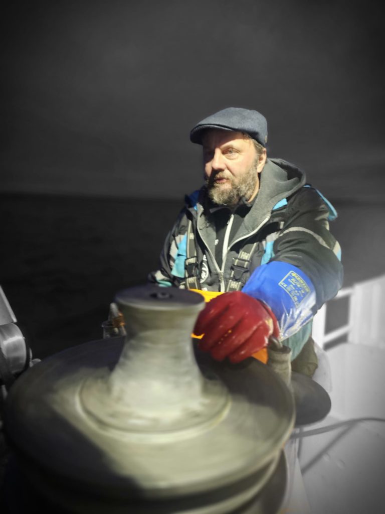 Nel cuore del Parco Schuster, tra i Sami in abiti tradizionali e i frati della Confraternita, il rituale del “Bang Bang Stockfish”: battere il pesce essiccato con il martello di legno per ammorbidirlo prima della cottura